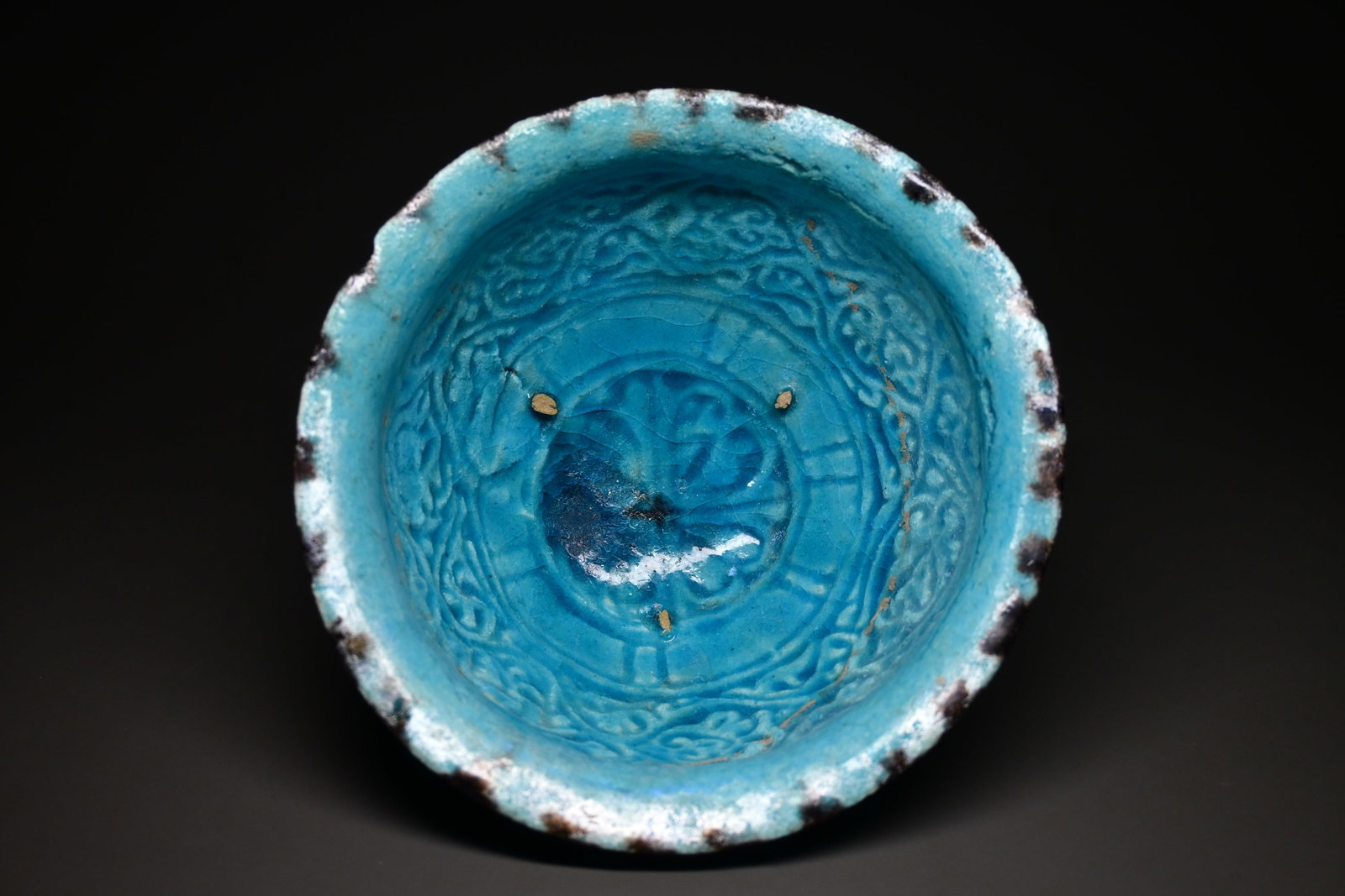 A turquoise kashan pottery bowl 12th-13thC: finely potted Kashan turquoise-glazed bowl of conical form, decorated to the interior with deeply engraved scrolling vegetal motifs surrounding a central medallion12-13thC.Size 16cm diameter.Provenanc