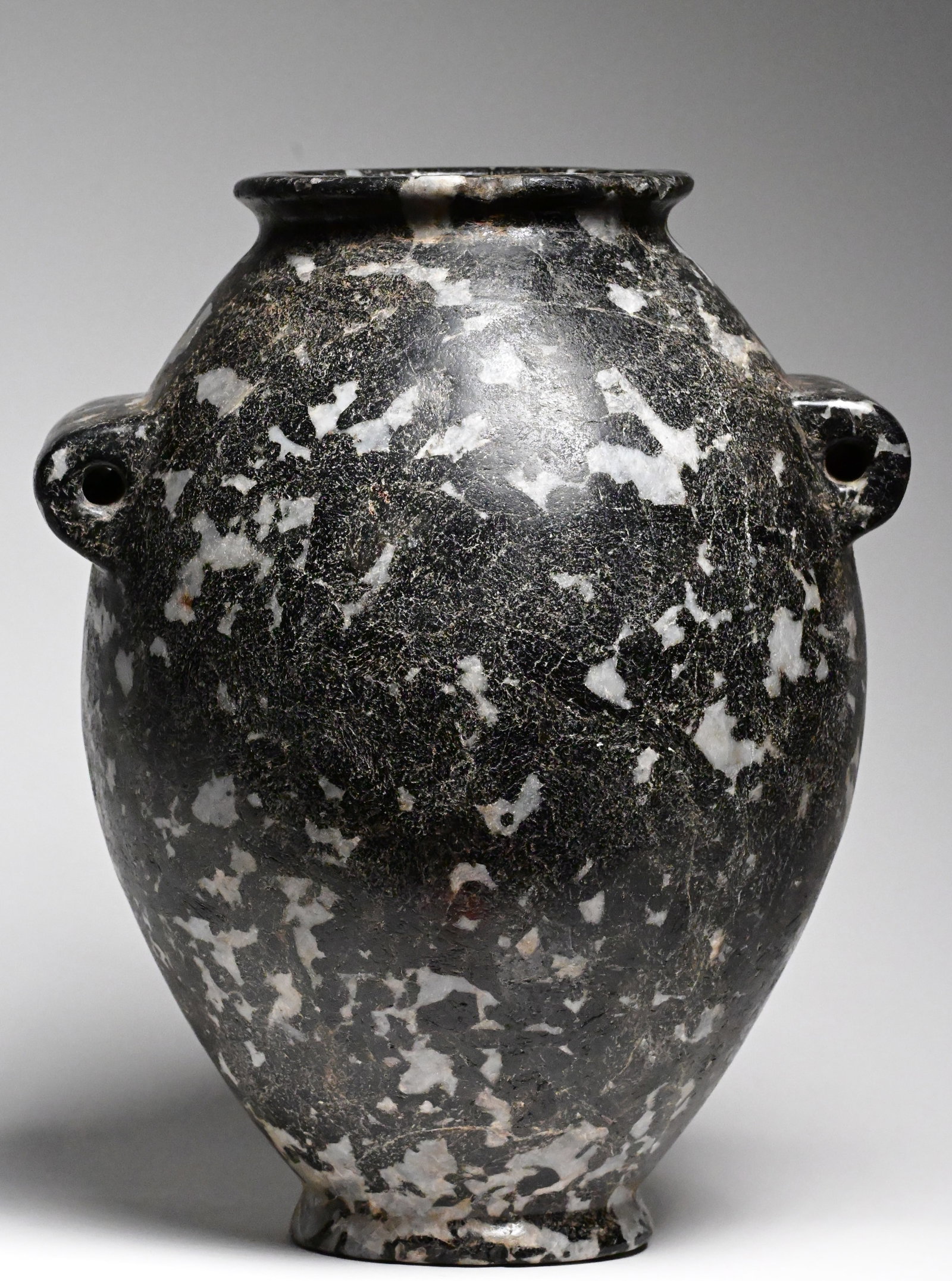 An Egyptian hornblende diorite jar: An Egyptian hornblende diorite flattened jarPredynastic Period, Naqada II, circa 3500-3200 B.C.26cm H x 10cm mouth diameterProvenance: property of an private european collector, acquired in early 1970
