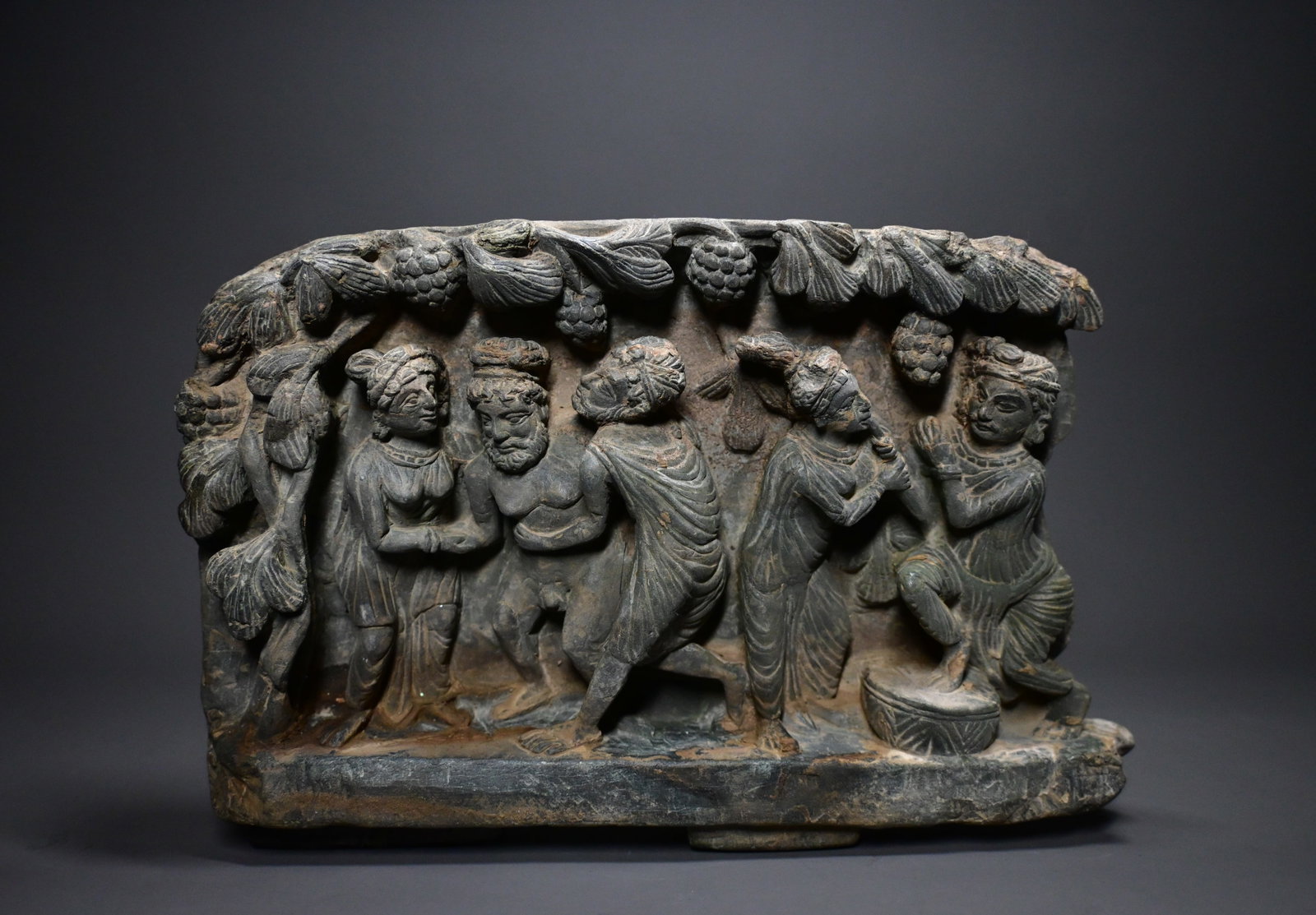 A Greco-Gandharan Grey Schist Relief Panel Gandhara, 2nd–4th Century A.D.: A Greco-Gandharan Grey Schist Relief PanelGandhara, 2nd–4th Century A.D.Size: 17cm H x 27cm....Provenance: property of an european collector, acquired in early 1990s
