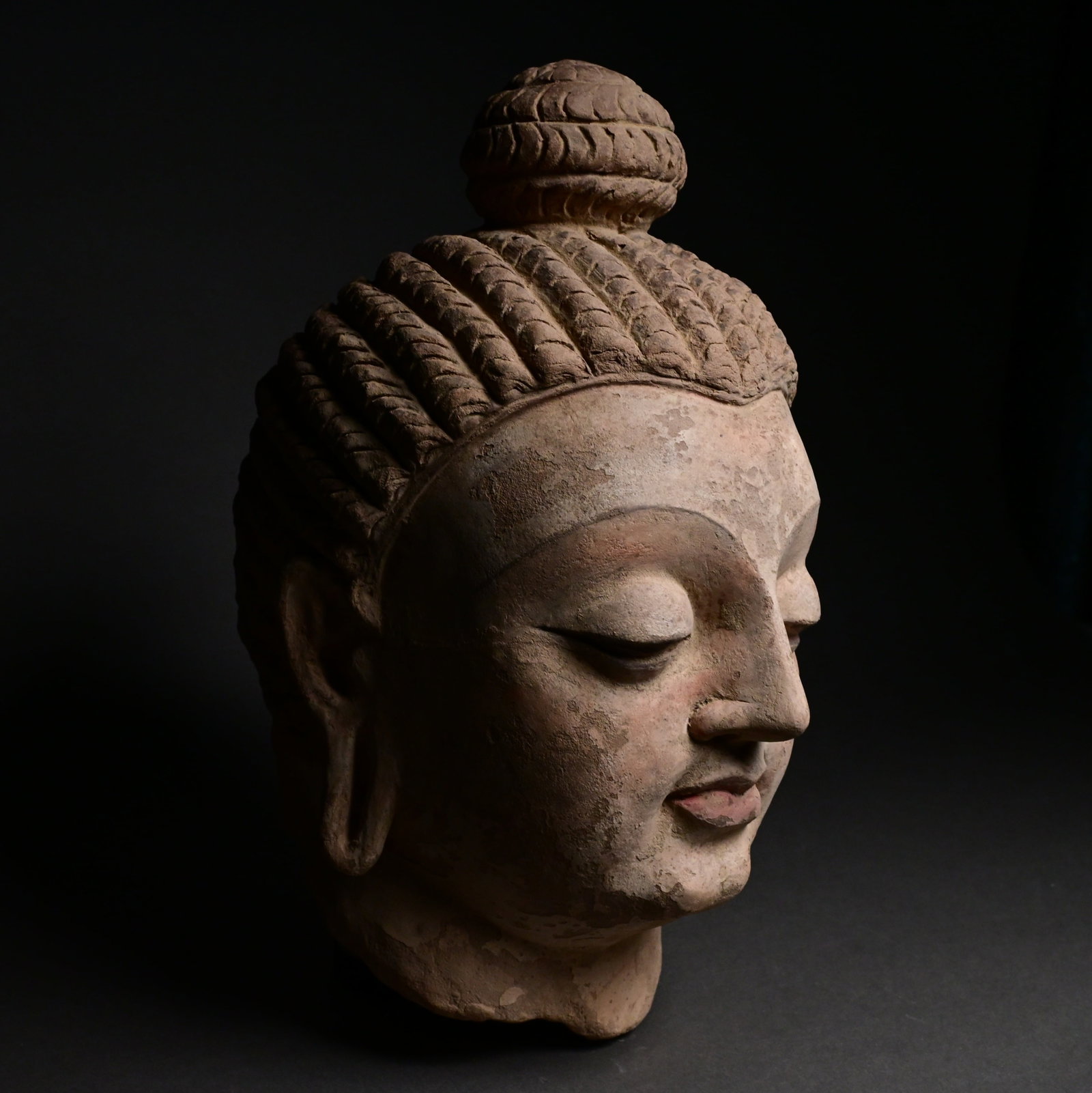 A Gandhara Head of a Buddha: Head of a Buddha,Pakistan (ancient region of Gandhara) or Afghanistan,3rd–4th century...Made out of clay (unbaked) polychromed.Size:32cm H.Provenance: property of an european collector, acquired in 