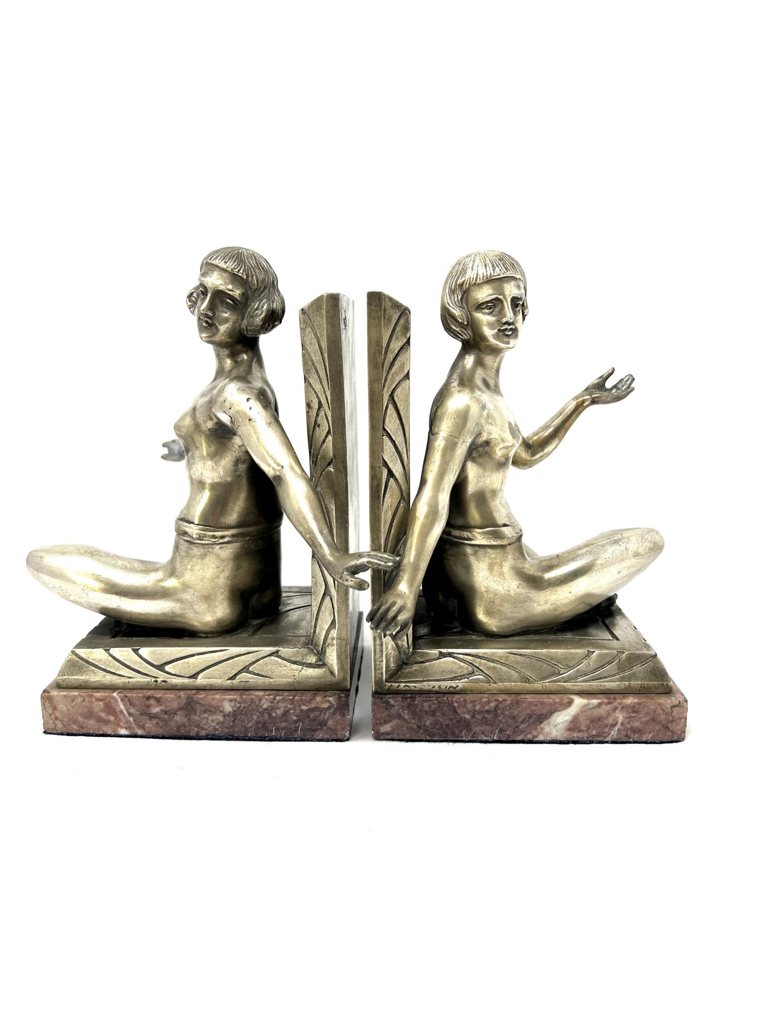 Large pair of French Art Deco figural bookends: A large pair of Frenchl Art deco figural silver plated metal and red marble bookends featuring partly nude seated women. Signed indistictly but stamped with a " fabrication francaise" seal. Approximat