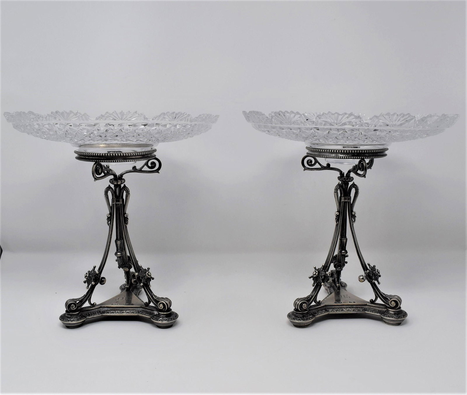 Pair of Victorian Elkington & Co. STERLING SILVER and cut glass tazzas: A pair of Victorian Sterling silver tazzas, Elkington & Company, Birmingham, 1854, the shallow cut glass bowls resting on a pierced etruscan revival tripod platform. Fully hallmarked with Birmingham s