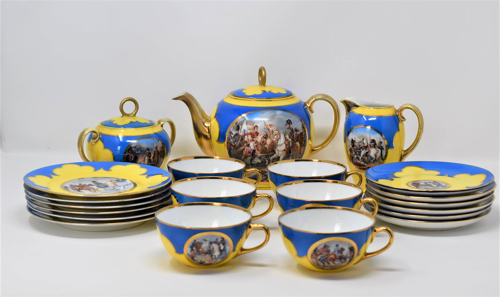 A Vintage Carlsbad, Czechoslovakia Napoleon tea service: A Vintage Carlsbad, Czechoslovakia Napoleon bonaparte themed bi-color blue and yellow porcelain tea service comprised of a tea pot, a covered sugar, a creamer, six tea cups and saucers and six desert