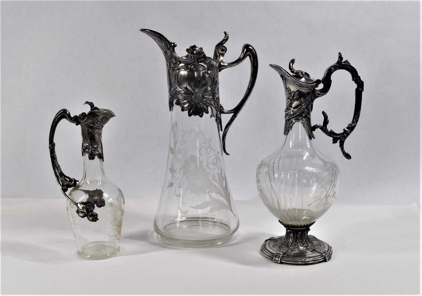 A grouping of three antique silver plate and glass claret jugs (1 of 19)