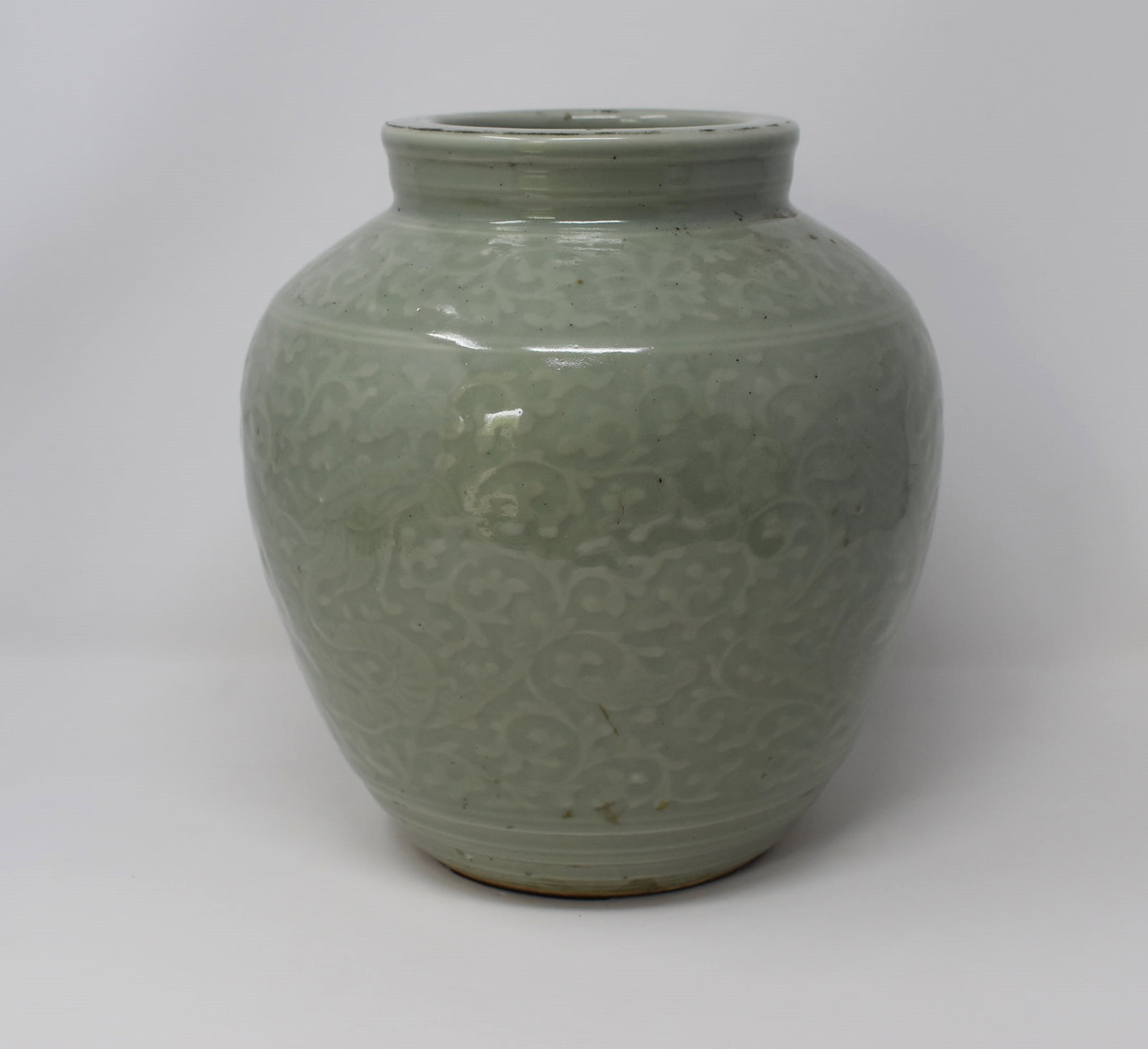 large Chinese celadon glazed ceramic vase: A large Chinese celadon glazed carved ceramic vase. Age un-known. Was drilled to be mounted as a lamp. Approximate measurements: 9"H x 8" in diameter Deker Auctions will not perform any shipping or pa