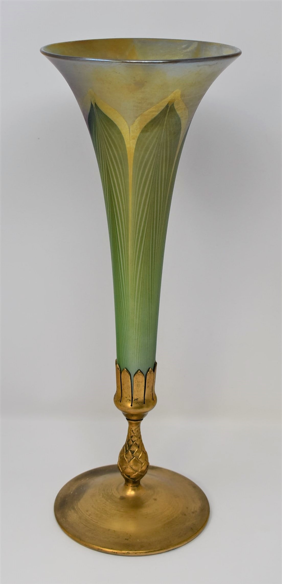 Signed Tiffany favrile glass trumpet vase: An Art Nouveau period Tiffany studios gilt brass and favrile glass trumpet vase. Marked Tiffany sudios on the underside as well numbered 1043. Glass engraved " favrile" From a Dix Hill NY estate. Meas