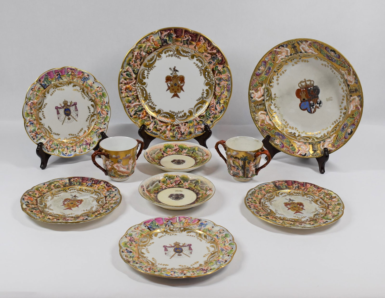 A grouping of early 19th century Capodimonte porcelain: A grouping of 10 early 19th century Capodimonte porcelain items, including a large Dinner plate dated 1806 on the back with un-identified Family Crest in its center, a large soup plate with an inscrip
