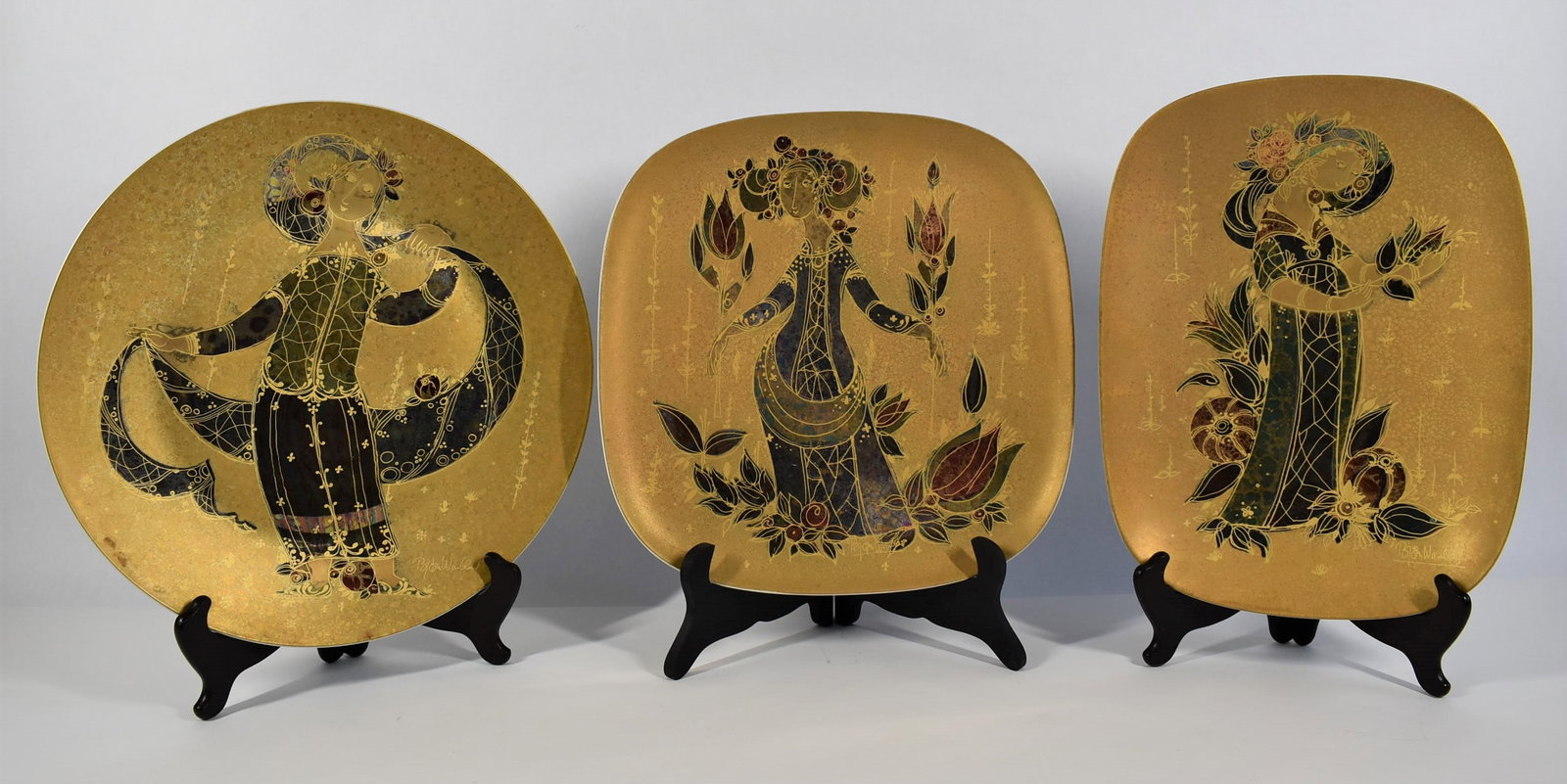 Grouping of Bjorn Wiinblad for Rosenthal porcelain trays: A grouping of three large vintage Bjorn Wiinblad for Rosenthal porcelain serving dishes / trays/ collector dispay plates with gilt decoration including a square dish/tray ( 1.75H x 12"W x 12"D), a cir