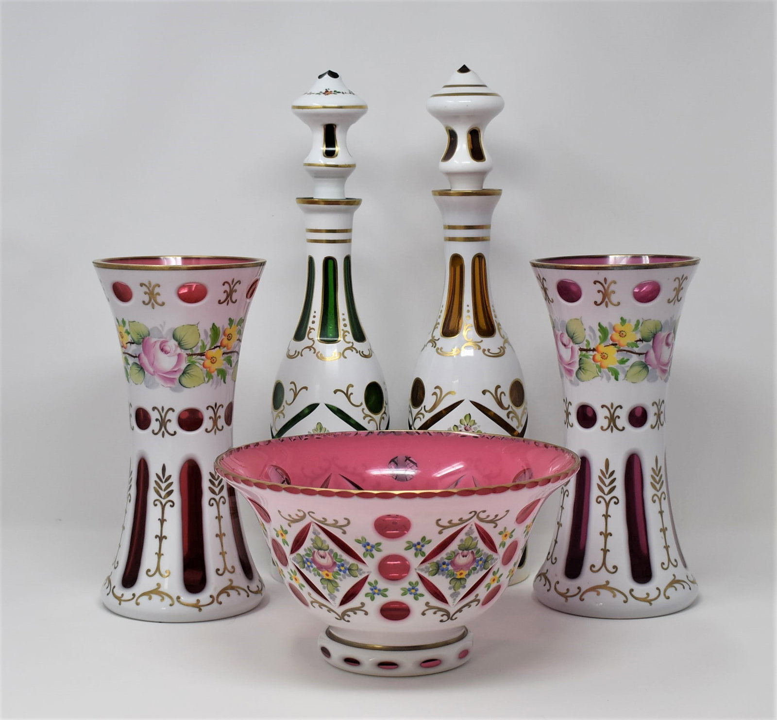Grouping of Bohemian overlay glass items: A grouping of 5 vintage Bohemian overlay glass items including two large decanters (16"H x 3.73" in diameter), a pair of vases (10"H x 5" in diameter) and a large bow l(5.25"h x 9.5" in diameter). Fro