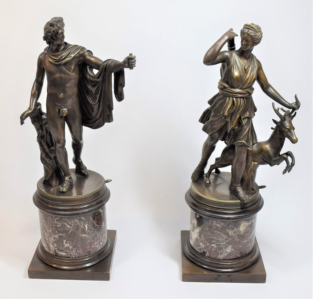 Pair of Neo-classical bronzes of Apollo and Diana: A pair of early 20th century neo-classical bronzes of Apollo and Diana the huntress on gyrating pedestal marble clad bases. Probably French, first quarter of the 20th century. Approximate measurements