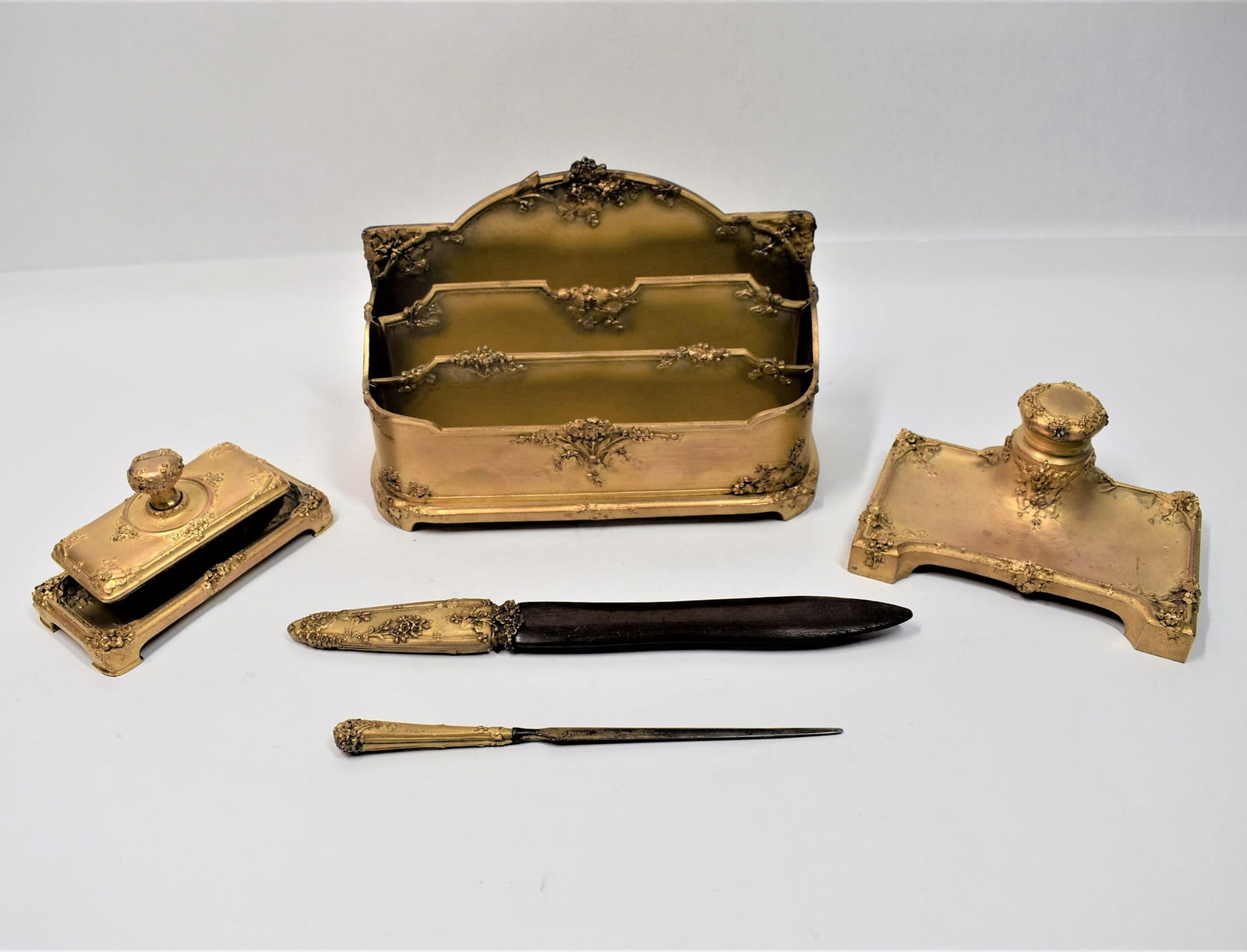 Guenardeau, Susse freres Gilt bronze desk set: A beautifully cast French Art Nouveau gilt bronze five-piece desk set designed by Guenardeau, comprising a letter rack, an inkwell, a blotter and two letter openers. Signed Guenardeau and Susse Freres