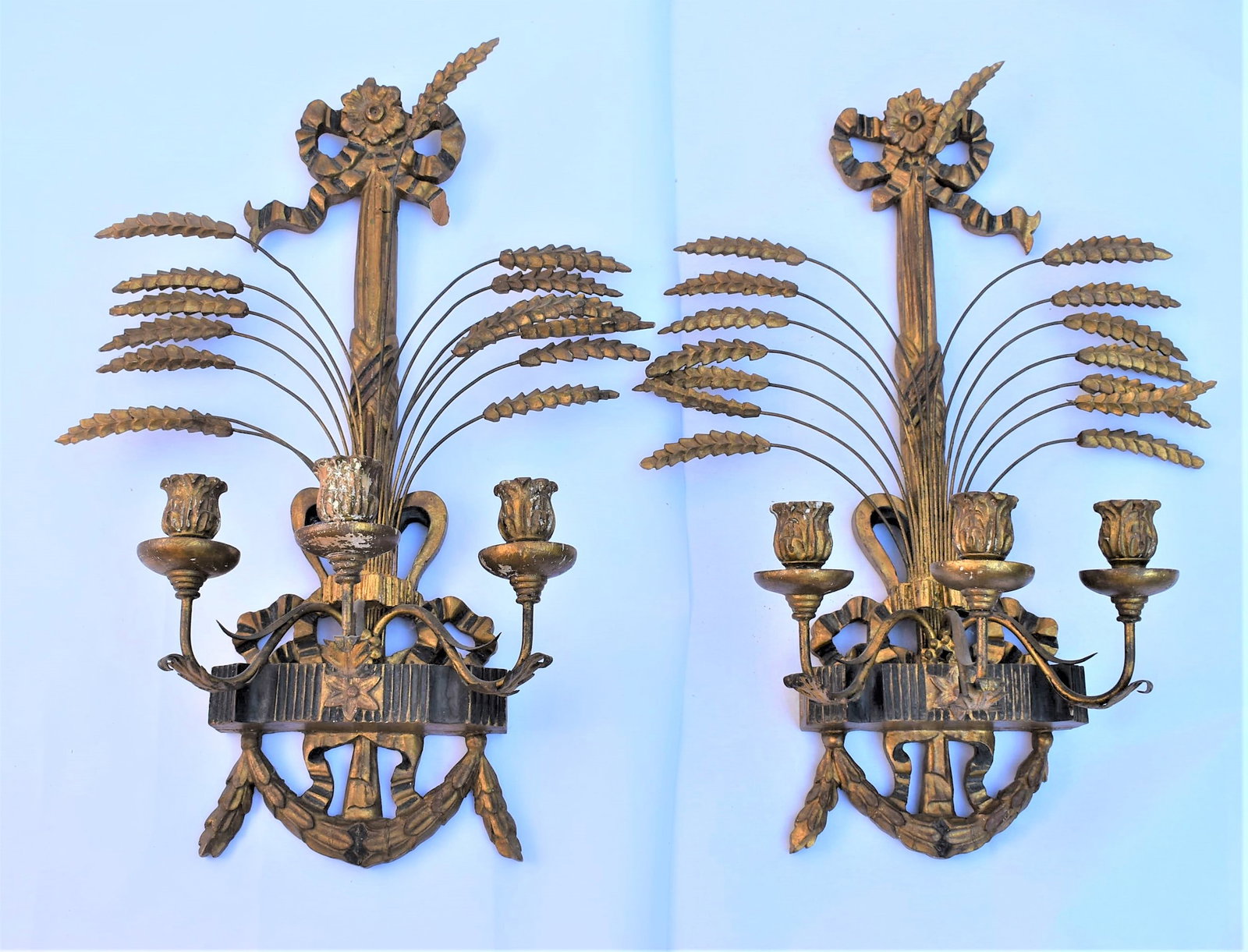 Pair of antique Italian gilt wood sheaf of wheat 2-arm sconces: A pair of antique or vintage Italian gitl wood and tole 18th century style sheaf of wheat and bows sconces / lights / appliques circa 1920's. Approximate measurements: 27"H x 20"W x 7"D Deker Auctions
