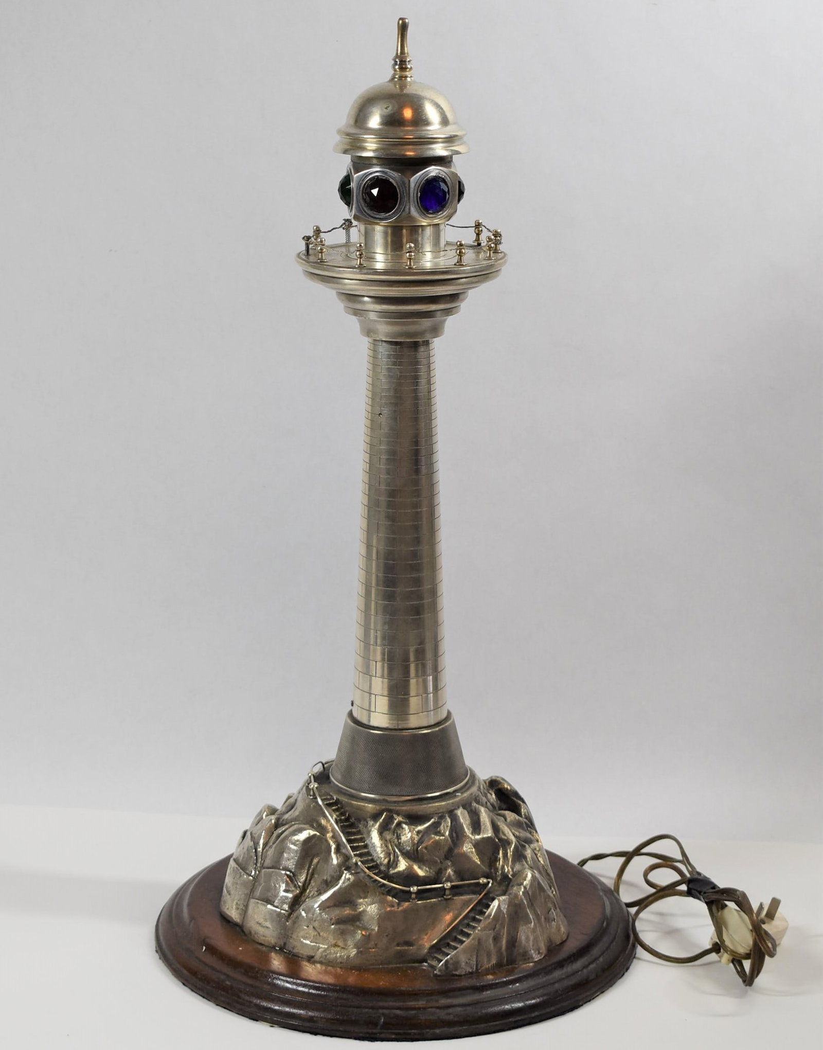 Large 23"-high 1930's lighthouse lamp: A large silver plated bronze Art deco period Lighthouse table lamp on original wood base, circa 1930's. Approximate measurements: 23"Hx 12" in diameter at the base. Deker Auctions will not perform any