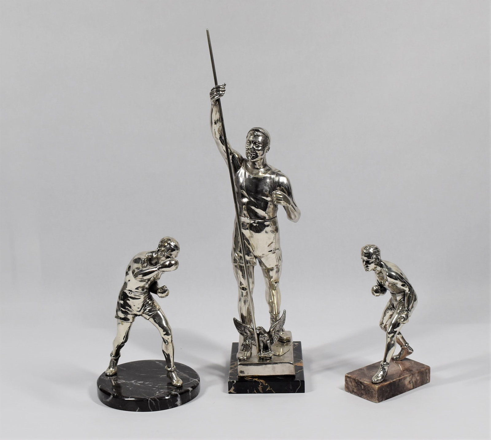 3 Art Deco silver plated Boxing and Pole-vault sculptures / trophies: A grouping of three Art deco period ( circa 1930's) continental silver plated metal sculpture / trophies on marble bases including two featuring boxers ( 8.25"h x 4.5"W x 2"D and 9"H x 5.5" in diamete