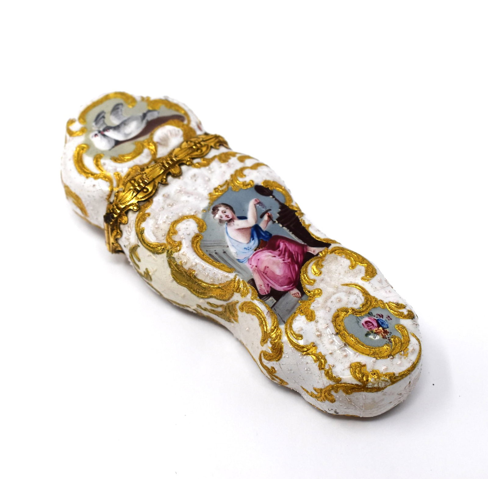 A South Staffordshire enamel etui with cream colored ground, circa 1770: A South Staffordshire enamel etui, circa 1770 of rococo form with light relief-moulded scrolled panels, the hinged gilt metal-mounted cover opening to reveal a full set of contents including scissors,