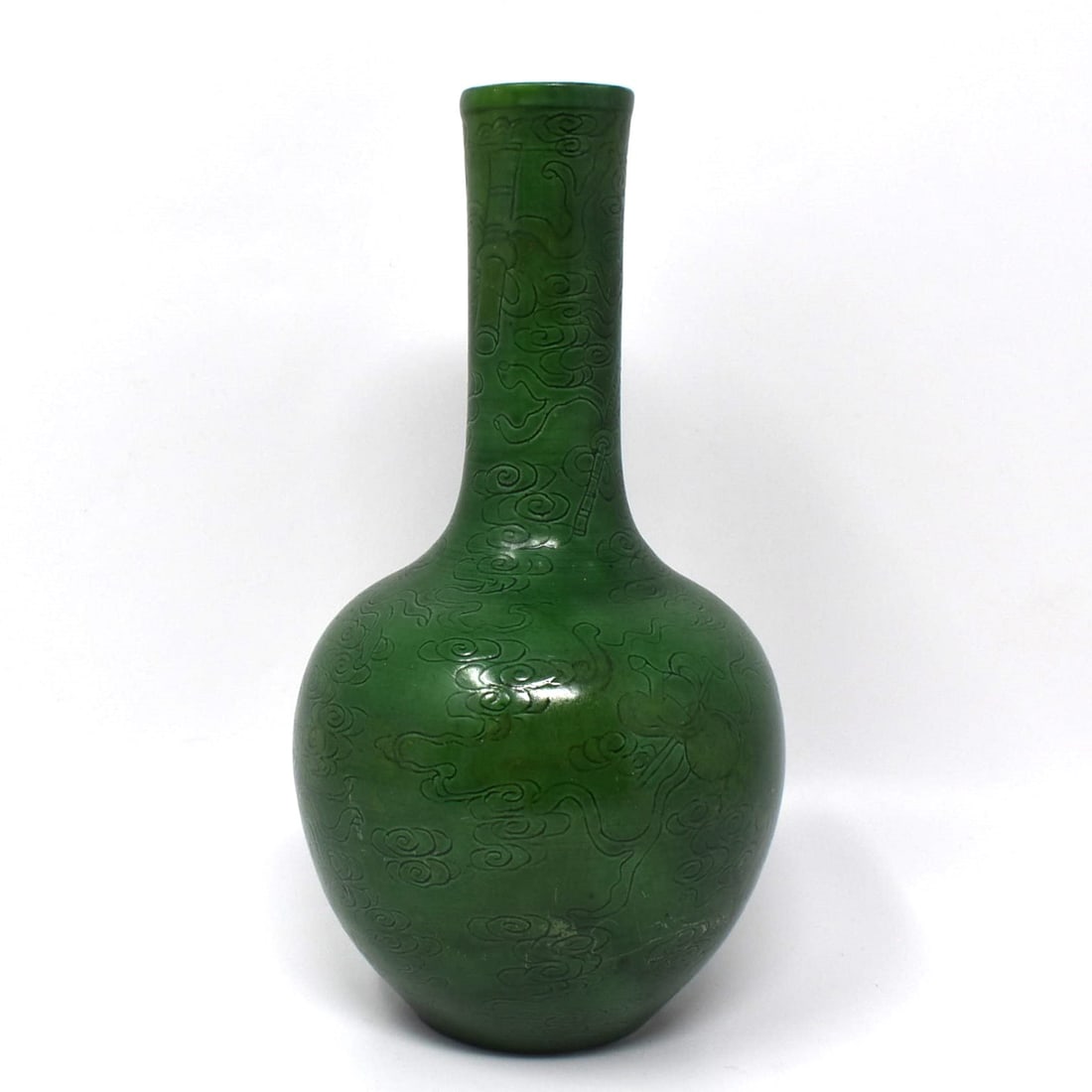 A Chinese apple-green glazed porcelain bottle vase with inscised decoration: A Chinese apple-green glazed bottle vase with inscised decoration of stylized clouds. Un-marked. From a Smithtown NY estate Approximate measurements: 8 3/4"H x 4 1/2" in diameter or 22.2cmH x 11.5cm i