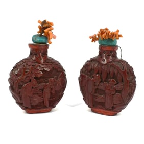 A pair of antique Chinese carved lacquer snuff bottles with coral stoppers