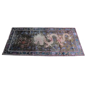 An antique Chinese silk rug with dragon motif