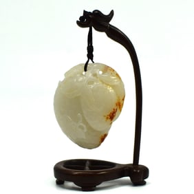 A Chinese White Jade Toggle with Stand