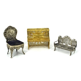A grouping of sterling silver & silver miniature furniture