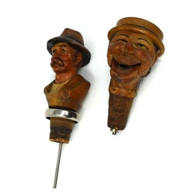A group of two German carved wood bottle stoppers