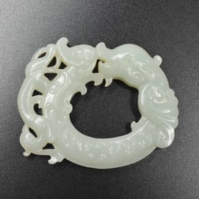 A Chinese carved celadon jade fish and phoenix pendant