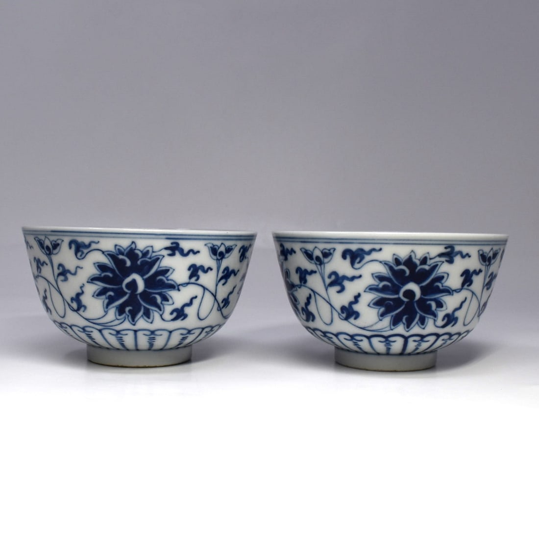 A pair of Chinese blue and white porcelain lotus cups: A pair of Chinese blue and white porcelain lotus cups. The underside with underglaze blue apocryphal? reign marks. From a Maryland estate. Approximate measurements: 2 1/4"H x 4 1/8" in diameter or 5.5