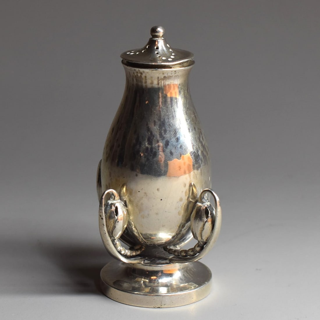 A GEORG JENSEN 'Blossom' sterling silver pepper shaker, model 2B: A Georg Jensen sterling 'Blossom' sterling silver pepper shaker, model 2B, featuring four iconic blossom buds on a stepped base. Circa 1933-1944. Weight: 1.91 Troy Oz or 59.7g Approximate measurements