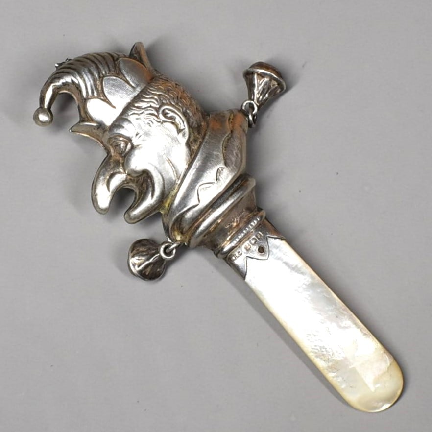 Antique English sterling silver and mother-of-pearl 'Mr. Punch' baby rattle: An antique English sterling silver figural baby rattle with mother-of pearl handle featuring a jester ' Mr. Punch'. Birmingham silver hallmarks, maker's marks for W.H. Collins & Co., 1933. Approximate