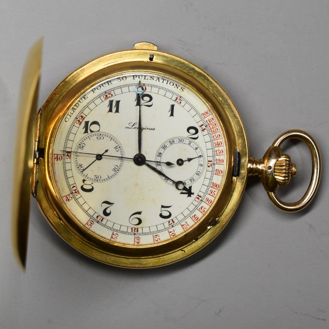 An antique LONGINES 18K gold keyless wind chronograph hunter cased pocket watch circa 1910: An antique LONGINES, Switzerland chronograph pocket watch for men, circa 1910, with 18k gold case. Cover with Monogram. Interior with 18k gold law, 'P&D' and number 7980132. Metal dust jacket engraved