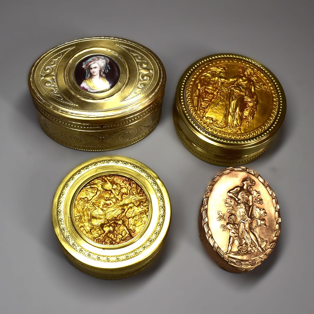 A grouping of Four gilt brass dresser boxes circa 1900, one by WMF: A grouping of Four gilt brass dresser boxes circa 1900, including an oval box by WMF with a porcelain plaque insert, the other three dresser boxes French. Approximate measurements (WMF box only, for s