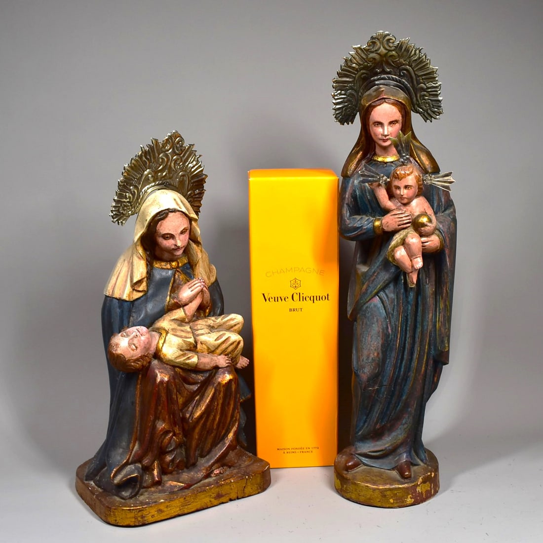 Two Santo figures of The Virgin and Child: A grouping of two 'Santo' figures of the Virgin and Child, both carved and polychromed wood and stamped metal halos. South America, 19th/20th century. The standing figure measuring 18"H x 4.5" in diam