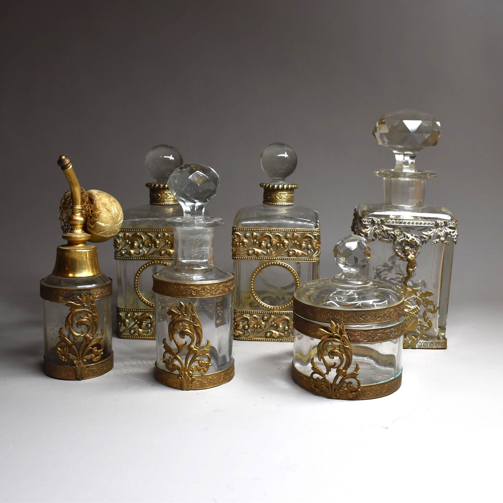 A grouping of antique French ormolu-mounted glass perfume bottles: A grouping of miscellaneous antique French ormolu-mounted perfume bottles and a dresser box and cover circa 1900. Some of them possibly by Baccarat, apparently un-signed. Approximate measurements ( ta