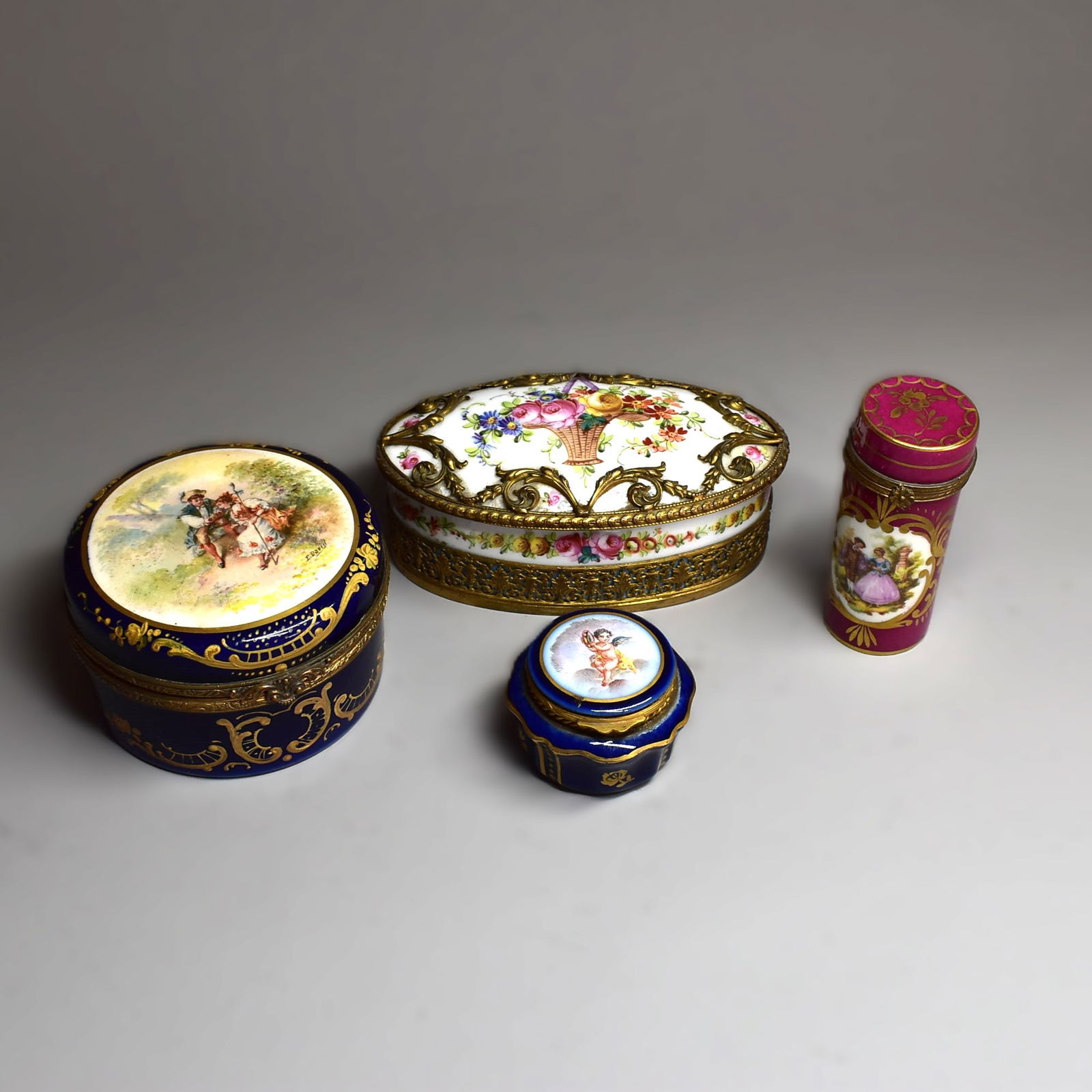 A grouping of 4 antique French Sevres/ Sevres style ormolu mounted porcelain dresser boxes: A grouping of antique French Sevres/ Sevres style ormolu mounted Louis XVI style porcelain dresser boxes and an etui. France, circa 1900. Approximate measurements (oval dresser box only, for scale): 2