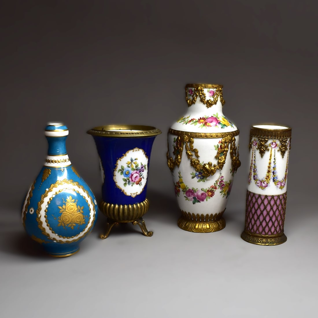 A grouping of 4 antique French Sevres/ Sevres style ormolu mounted porcelain vases: A grouping of four antique French Sevres/ Sevres style ormolu mounted porcelain vases circa 1900. All four vases with blue sevres/ sevres style marks on the underside. Approximate measurements (larges