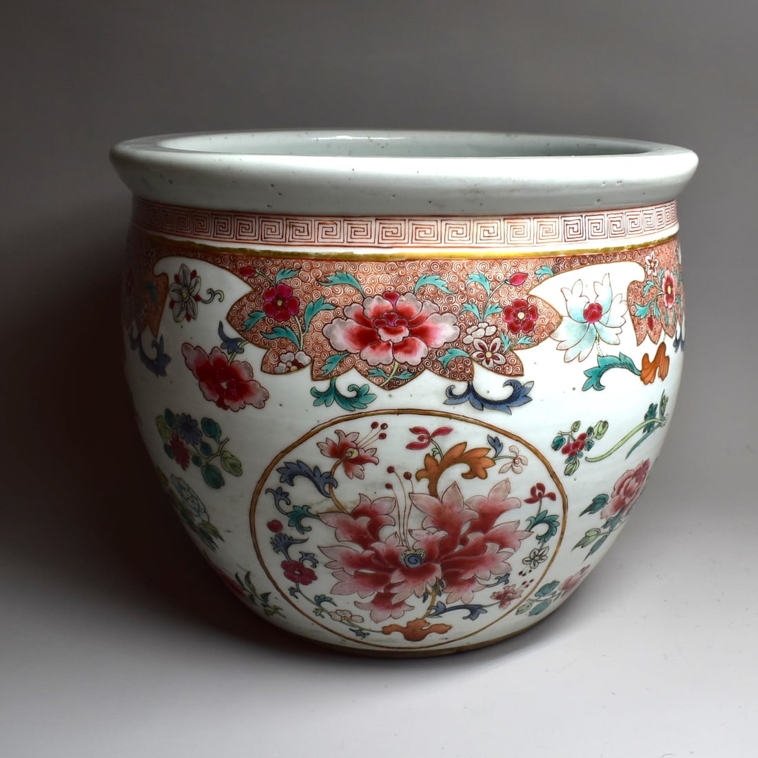 A Chinese famille Rose porcelain jardiniere, late Qing Dynasty: A late Qing Dynasty Chinese Famille Fose jardiniere / fish bowl, enamel decorated with floral motifs, with a ruyi border. Late Qing Dynasty, 19th century. Approximate measurements: 10"H x 12" in diame