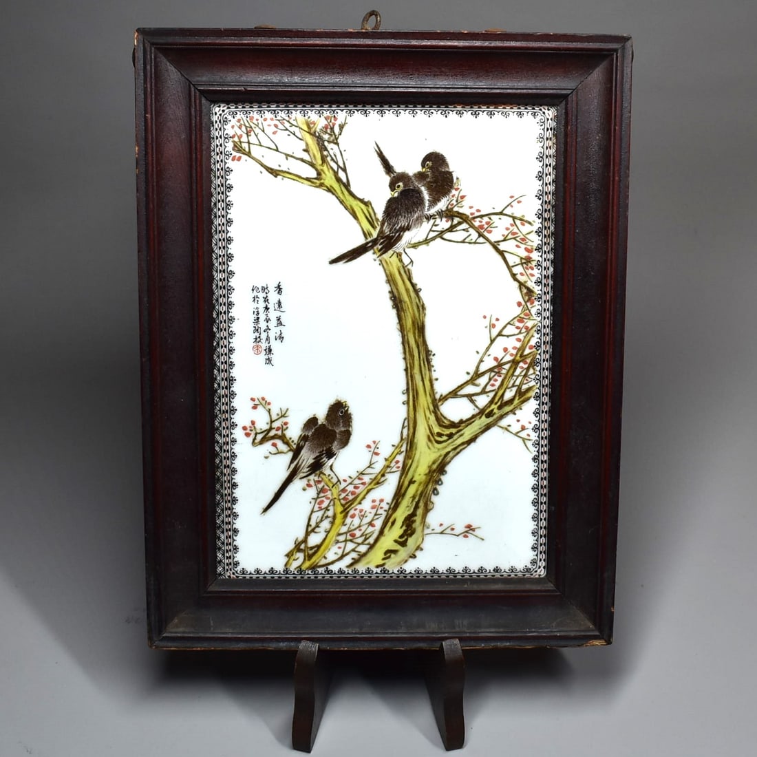 A Chinese Republic period Famille Rose porcelain plaque: A Chinese Republic period Famille Rose porcelain plaque featuring birds on a prunus tree. Sined on the left. Approximate measurements (overall, including frame): 12"H x 9 1/4"W or 30.5cm H x 23.5cm W