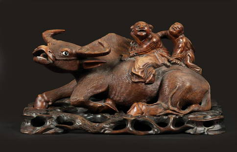 A hardwood sculpture of 2 figures on a water buffalo. China: A hardwood sculpture of 2 figures on a water buffalo. China, mid 20th century.H.: 19 x B.: 35 cm.