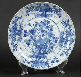 A porcelain dish with 4 compartment division outer rim and: A porcelain dish with 4 compartment division outer rim and flowers on rock center decor with insects. China, Kangxi.Diam.: 26,5 cm.