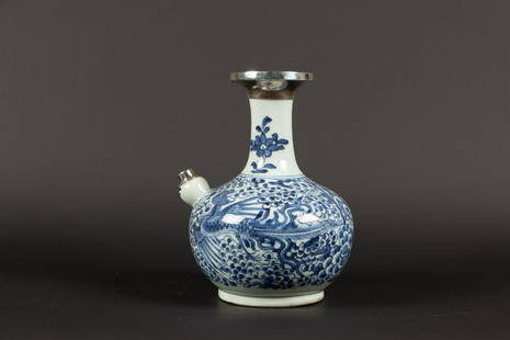 A porcelain kendi decorated with phoenixes, set with silver: A porcelain kendi decorated with phoenixes, set with silver on the spout and top. China, Kangxi.H.: 22,5 cm.