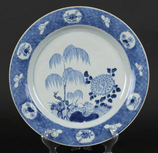 A porcelain dish with a decoration of a weeping willow amon: A porcelain dish with a decoration of a weeping willow among lotus flowers. China, Qianglong.Diam.: 34,5 cm.