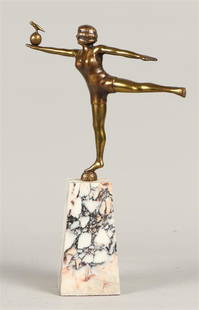 A polished bronze sculpture of a gymnast balancing on a bal: A polished bronze sculpture of a gymnast balancing on a ball. On a marble base.H.: 34 cm. incl. sokkel.