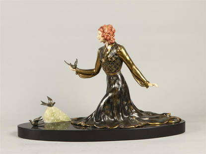 A cold-painted ZAMAC sculpture of a lady with birds on a ho: A cold-painted ZAMAC sculpture of a lady with birds on a honed marble base, 2nd half 20th century.35 x 54 cm.