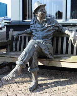 A life-size bronze garden statue of a man sitting on a benc: A life-size bronze garden statue of a man sitting on a bench. Second half of the 20th century.H.: 160 x B.: 120 cm.