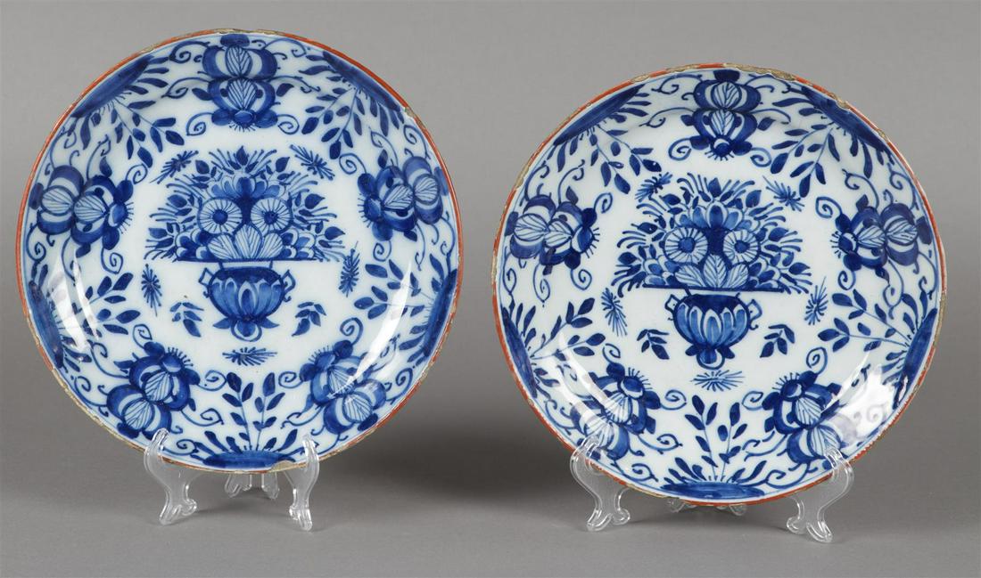 Een set van twee aardewerk borden met bloemenmand decor. De (1 of 2)