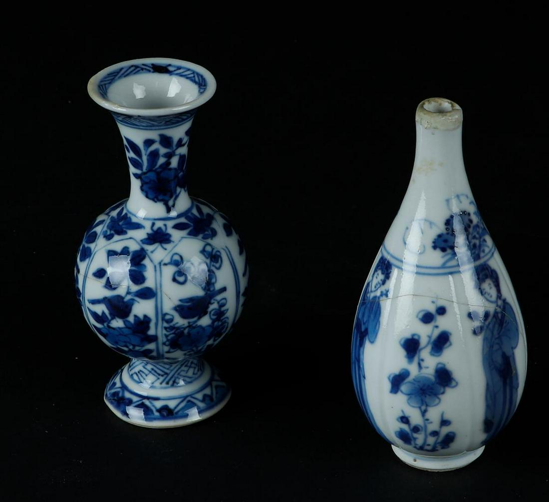 A porcelain ribbed vase with lily decoration on the belly & a belly vase: A porcelain ribbed vase with lily decoration on the belly & a belly vase with floral decor in lotus leaf shaped beds. China, Kangxi.H.: 9,5 cm.