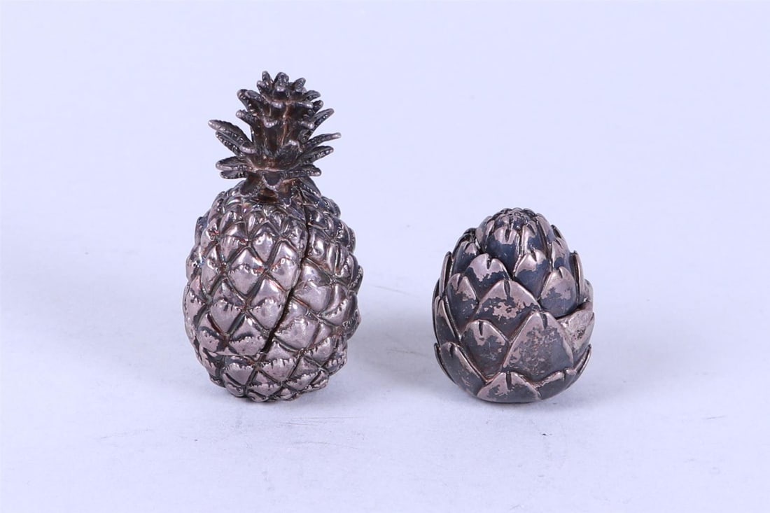 A lot consisting of (2) novelty pill boxes in the shape of an artichoke and a pineapple. 835/1000.: A lot consisting of (2) novelty pill boxes in the shape of an artichoke and a pineapple. 835/1000. Weight 127 grams.H.: 6,5 cm.