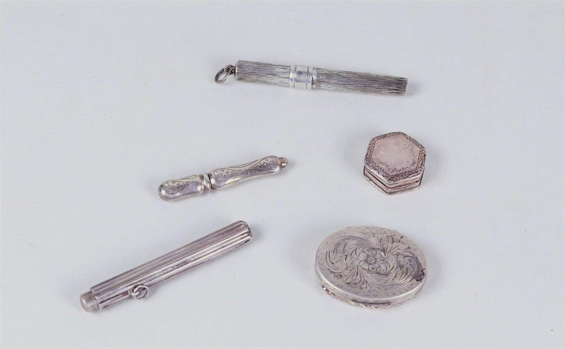 A lot consisting of (2) silver pill boxes, (2) pencil holders, and a needle case: A lot consisting of (2) silver pill boxes, (2) pencil holders, and a needle case. All 2nd grade and dating from the late 19th and early 20th century.