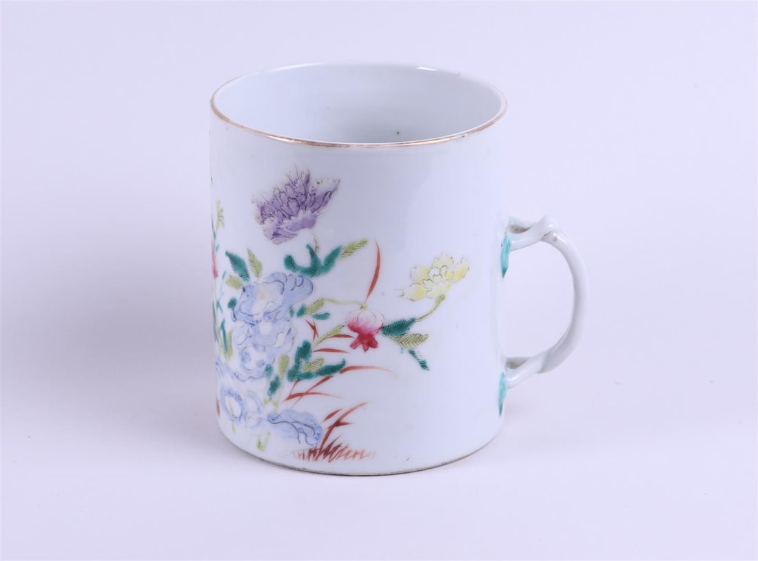 A porcelain Famille Rose cup with woven handle with rich floral decoration on rock decor with bird: A porcelain Famille Rose cup with woven handle with rich floral decoration on rock decor with bird and insects. Marked with seal mark. China 19th/20th century.H 11 cm Diam. 9.5 cm.