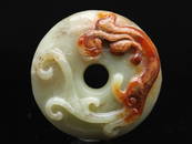 A white and gold skin jade Bi disc with chilong, early Qing Dynasty (Bonhams London)